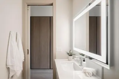a white bathroom with a sink and a mirror at Brand New Condo - Walk to Empower Stadium - Tesoro in Denver