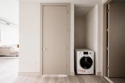 a washing machine in a room with a door at Brand New Condo - Walk to Empower Stadium - Tesoro in Denver