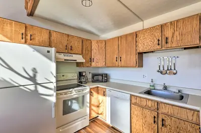 a kitchen with wooden cabinets and a refrigerator at Mtn-View Silverthorne Gem with Shared Hot Tub in Silverthorne
