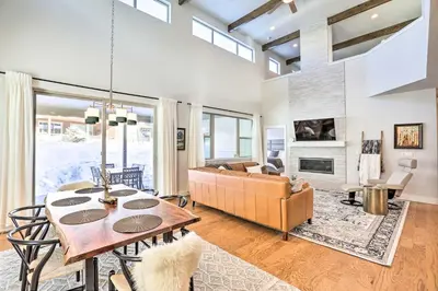 a living room with a table and a couch at Hike and Ski Stunning Home with Hot Tub in Granby! in Granby