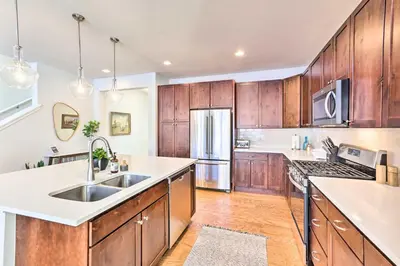 a kitchen with wooden cabinets and a stainless steel refrigerator at Hike and Ski Stunning Home with Hot Tub in Granby! in Granby