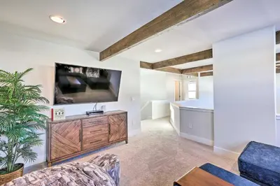 a living room with a tv on a wall at Hike and Ski Stunning Home with Hot Tub in Granby! in Granby