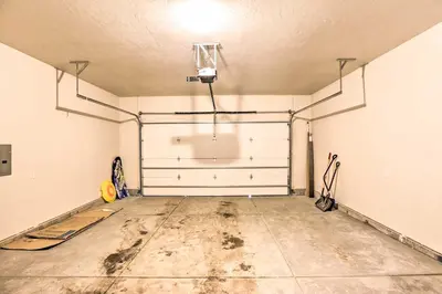 a garage with two white doors and a concrete floor at Hike and Ski Stunning Home with Hot Tub in Granby! in Granby
