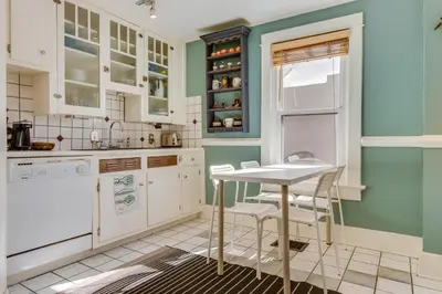 a kitchen with white cabinets and a table and chairs at 2 Mi to Washington Park Convenient Denver Home! in Denver