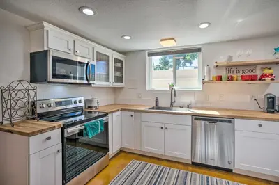 a kitchen with white cabinets and a sink at 4 Mi to Coors Field Charming Apartment with Patio in Denver