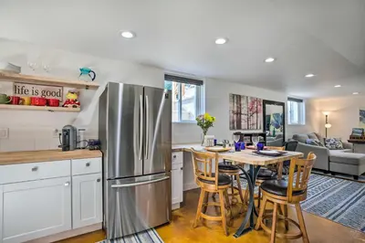 a kitchen with a stainless steel refrigerator and a table at 4 Mi to Coors Field Charming Apartment with Patio in Denver