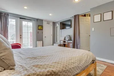 a bedroom with a large bed and a kitchen at Platt Park Studio with Patio Walkable Location! in Denver