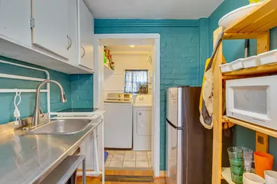 a kitchen with a sink and a refrigerator at Platt Park Studio with Patio Walkable Location! in Denver