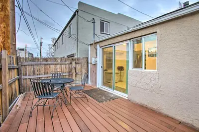 a patio with a table and chairs on a wooden deck at Walk to Tennyson St! Pet-Friendly Denver Home in Denver