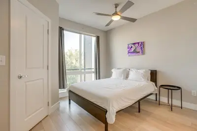 a bedroom with a bed with a ceiling fan and a window at Rooftop Deck and Hot Tub Walkable Denver Townhome in Denver