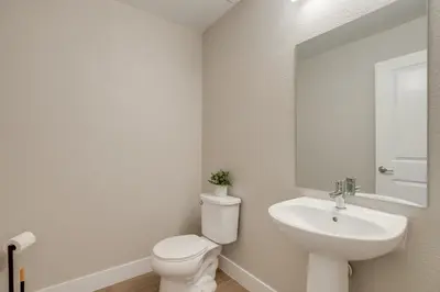 a bathroom with a toilet and a sink and a mirror at Rooftop Deck and Hot Tub Walkable Denver Townhome in Denver