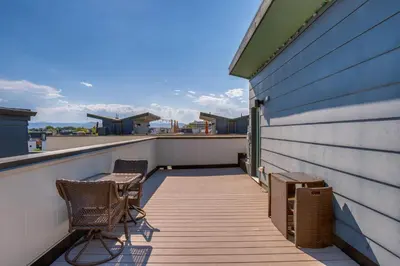 a balcony with two chairs and a building at Rooftop Deck and Hot Tub Walkable Denver Townhome in Denver