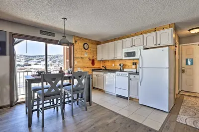 a kitchen with a white refrigerator and a table with chairs at Granby Studio with Mtn Views Near Hiking and Skiing! in Granby