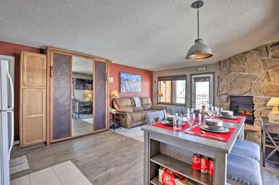 a kitchen and living room with a stone wall at Granby Studio with Mtn Views Near Hiking and Skiing! in Granby
