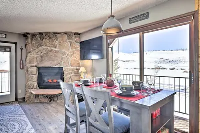 a dining room with a table and a fireplace at Granby Studio with Mtn Views Near Hiking and Skiing! in Granby