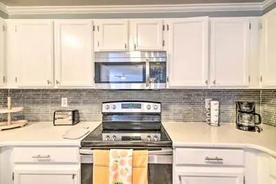 a kitchen with white cabinets and a stove top oven at Loveland Duplex with Large Yard 2 Mi to Dtwn in Loveland