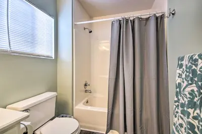 a bathroom with a shower curtain and a toilet at Loveland Duplex with Large Yard 2 Mi to Dtwn in Loveland