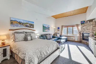 a bedroom with a large bed and a fireplace at Walk to Lifts Studio with Hot Tub in Keystone! in Keystone