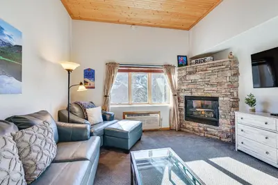 a living room with a couch and a fireplace at Walk to Lifts Studio with Hot Tub in Keystone! in Keystone