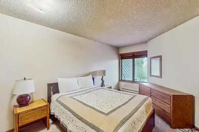 a bedroom with a bed and a window at Lookout Lounge in Fraser
