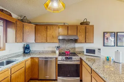 a kitchen with wooden cabinets and a stove top oven at Lookout Lounge in Fraser