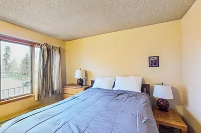 a bedroom with a bed with two lamps and a window at Lookout Lounge in Fraser