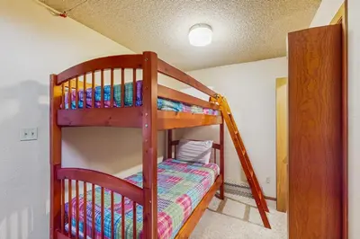 a bunk bed in a room with a ladder at Lookout Lounge in Fraser