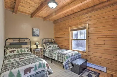 a bedroom with two beds in a log cabin at Black Hawk Mountain Cabin about 4 Mi to Casinos! in Black Hawk