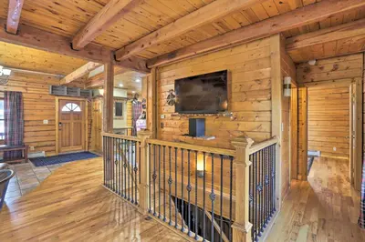 a living room with wooden walls and a tv on a wall at Black Hawk Mountain Cabin about 4 Mi to Casinos! in Black Hawk