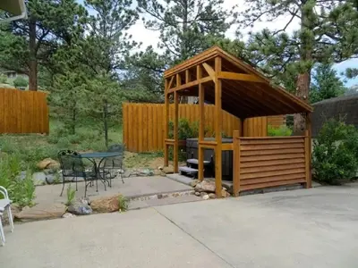 a wooden gazebo with a table and a table at Bear House -- EV #3073 home in Estes Park