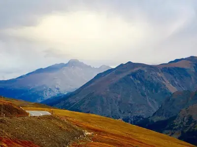 a road on a hill with mountains in the background at Bear House -- EV #3073 home in Estes Park