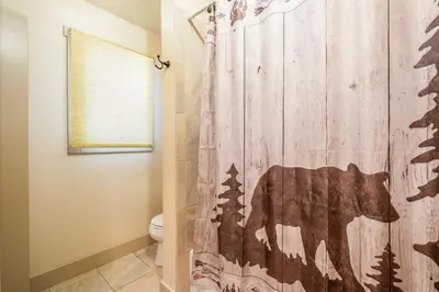 a shower curtain with a bear on it in a bathroom at Bear House -- EV #3073 home in Estes Park