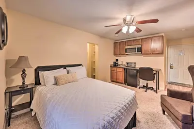 a bedroom with a bed with a ceiling fan and a kitchen at 2 Blocks to Light Rail Denver Unit with Kitchenette in Greenwood Village