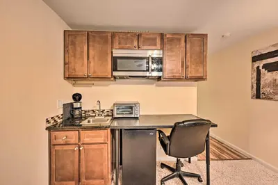 a kitchen with a counter with a chair and a microwave at 2 Blocks to Light Rail Denver Unit with Kitchenette in Greenwood Village