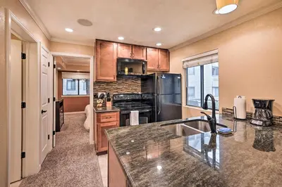 a kitchen with a sink and a stove top oven at Condo with Patio and Pool Access in Greenwood Village! in Greenwood Village