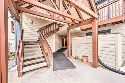 a house with a wooden staircase and a garage at Condo with Patio and Pool Access in Greenwood Village! in Greenwood Village