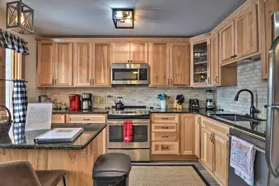 a kitchen with wooden cabinets and stainless steel appliances at Cozy Mountain Getaway with Ski Shuttle Access! in Fraser