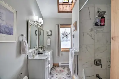 a white bathroom with a sink and a shower at Cozy Mountain Getaway with Ski Shuttle Access! in Fraser