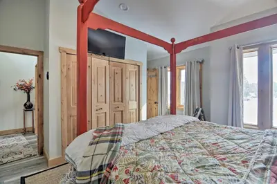 a bedroom with a bed with a red canopy at Cozy Mountain Getaway with Ski Shuttle Access! in Fraser