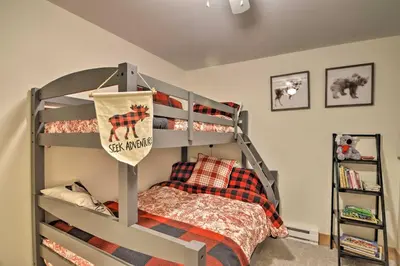 a bedroom with a bunk bed with a plaid bedspread at Cozy Mountain Getaway with Ski Shuttle Access! in Fraser