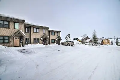 a snow covered street in front of a house at Cozy Mountain Getaway with Ski Shuttle Access! in Fraser