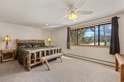 a bedroom with a bed and a ceiling fan at Lily Mountain Lodge - Amazing Mountains Views, Private Hot Tub, Great Location in Estes Park