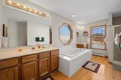 a bathroom with a large tub and a large mirror at Lily Mountain Lodge - Amazing Mountains Views, Private Hot Tub, Great Location in Estes Park