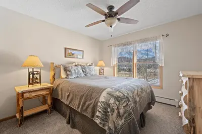 a bedroom with a bed and a ceiling fan at Lily Mountain Lodge - Amazing Mountains Views, Private Hot Tub, Great Location in Estes Park
