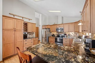 a large kitchen with wooden cabinets and a marble counter top at Lily Mountain Lodge - Amazing Mountains Views, Private Hot Tub, Great Location in Estes Park