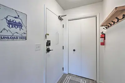 a hallway with a white door and a sign on the wall at Walkable Winter Park Condo about 4 Mi to Slopes! in Winter Park