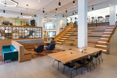 a lobby with tables and stairs in a building at Sentral Union Station in Denver
