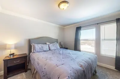 a bedroom with a large bed and a window at Quail Nest on Quail Drive in Fraser