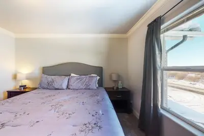a bedroom with a bed and a window at Quail Nest on Quail Drive in Fraser