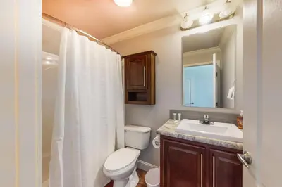 a bathroom with a toilet and a sink and a mirror at Quail Nest on Quail Drive in Fraser